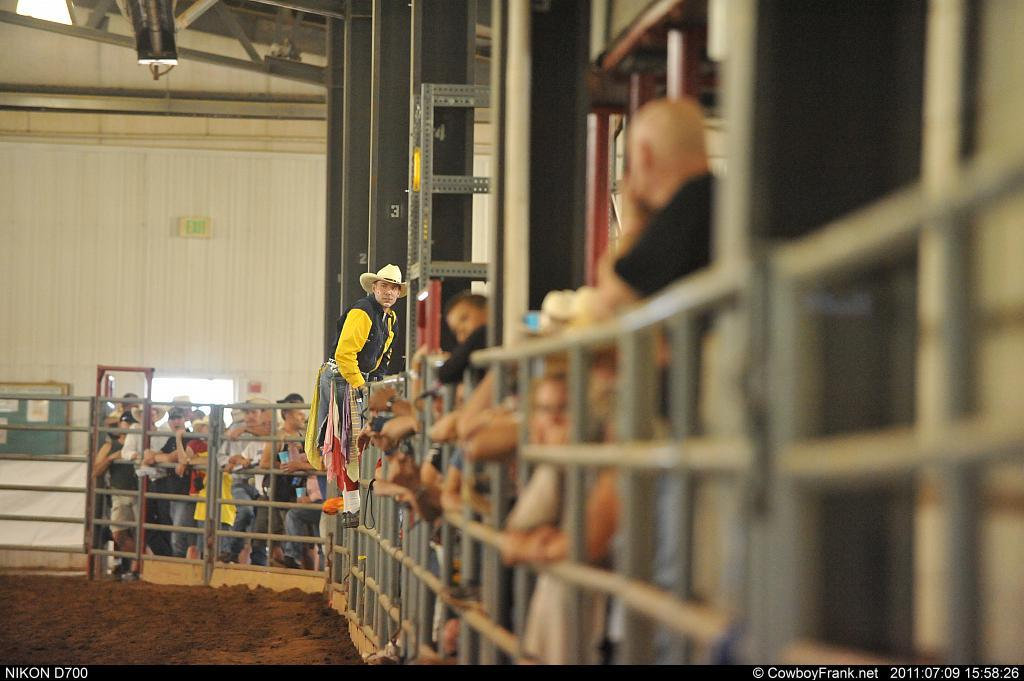Cowboy and spectators beside the chutes at a CGRA rodeo